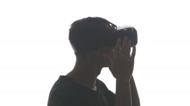 Vr-kulaklık, beyaz arka plan üzerinde izole kullanarak deneyim elde kulaklıklar bir genç adam silüeti