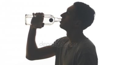 Beyaz arka plan üzerinde izole bir şişe votka içme bir sarhoş adam silüeti