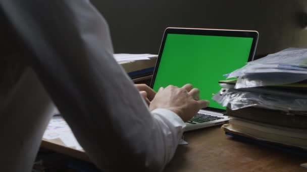 El hombre trabaja en el ordenador portátil de la oficina ot tarde con pantalla verde. Empresario trabajando de noche en la computadora con Choma Key . — Vídeo de stock