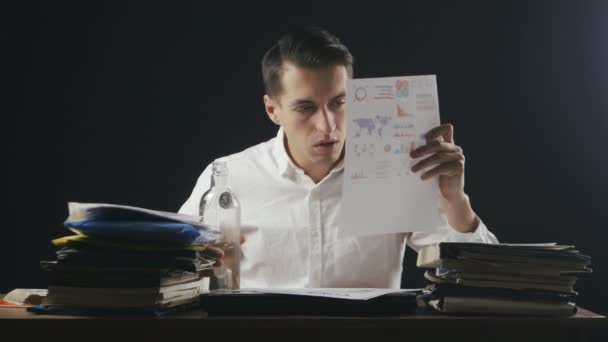 L'uomo d'affari stanco stressato beve vodka sul posto di lavoro. Direttore beve l'alcool a ufficio di notte . — Video Stock