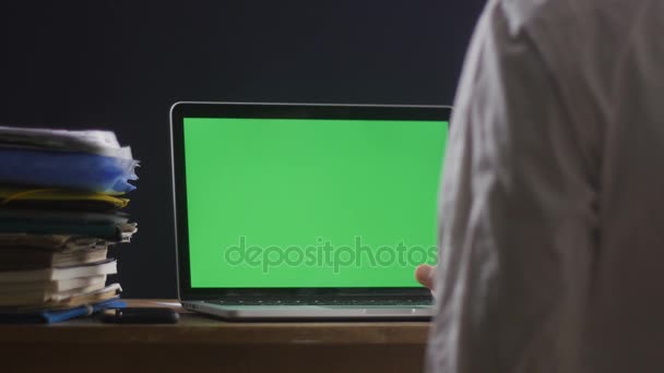 Primer plano del hombre trabaja en el ordenador portátil de la oficina ot tarde con pantalla verde. Empresario trabajando de noche en la computadora con Choma Key . — Vídeo de stock