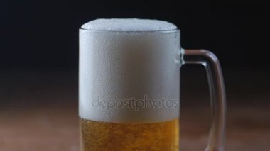 Siyah arka plan, bir bardak soğuk ışık bira yavaş hareket