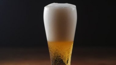 Bira bardağına siyah arka plan üzerine yağıyor. Ağır çekim