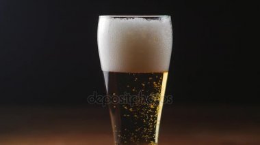 Siyah arka plan, bir bardak soğuk ışık bira yavaş hareket