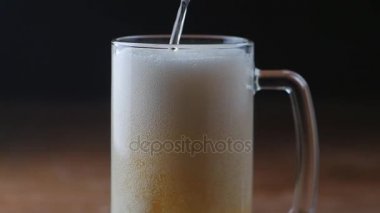 Bira bardağına siyah arka plan üzerine yağıyor.