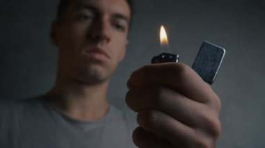 Genç adam bir zippo çakmak aydınlatma yakın çekim