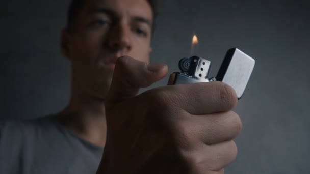 Gros plan d'un jeune homme allumant un briquet zippé — Video