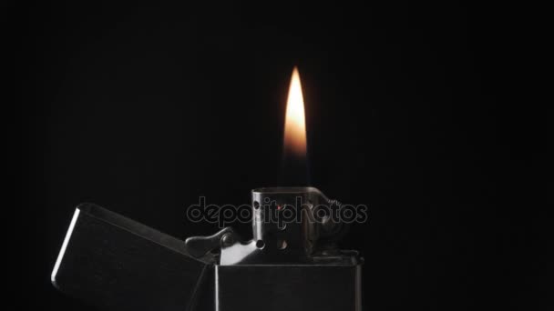 Open metal lighter zippo with flame on black background — Stock Video