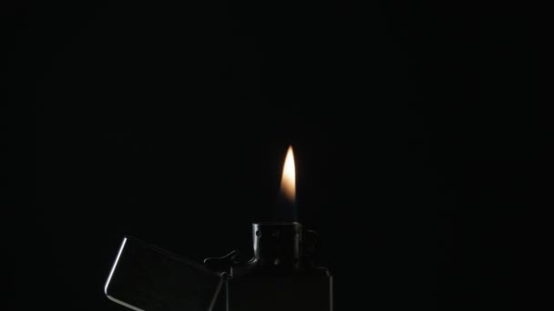 Открытая металлическая зажигалка Zippo с пламенем на черном фоне — стоковое видео