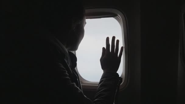 Jovem viaja de avião e senta-se à janela e desfruta da vista — Vídeo de Stock