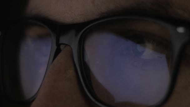 Zblízka reflexe na brýle a oči mladého muže, procházení webových stránek na internetu — Stock video