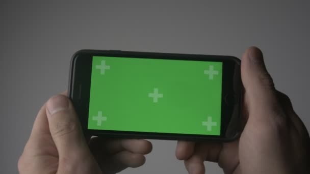Yakın kadar adam tutarak Smartphone dokunmatik ile yeşil ekran Chroma Key yatay pozisyonda — Stok video