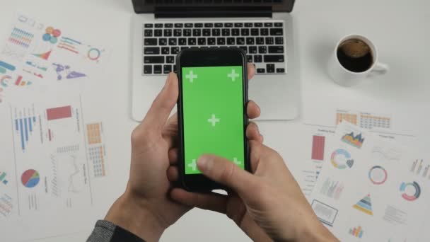 Man met smartphone aanraking met Chromakey, key groen scherm op witte office tabelachtergrond. Bovenaanzicht. Kantoor spullen op Bureau achtergrond. — Stockvideo