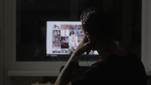 Joven hombre viendo surf pornografía sitio en la web por la noche en casa — Vídeo de stock