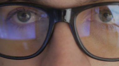 Yakın çekim yansıma gözlüklü bir adam bir film izlerken. Çift pozlama video izlerken biri. Makro