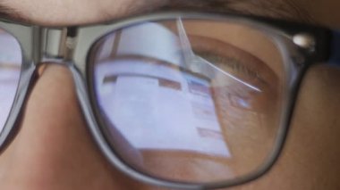 Gözlük ve genç adamın web sitelerine internette sörf yansıması yakın çekim