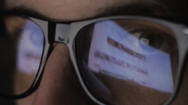 Gözlük ve genç adamın web sitelerine internette sörf yansıması yakın çekim