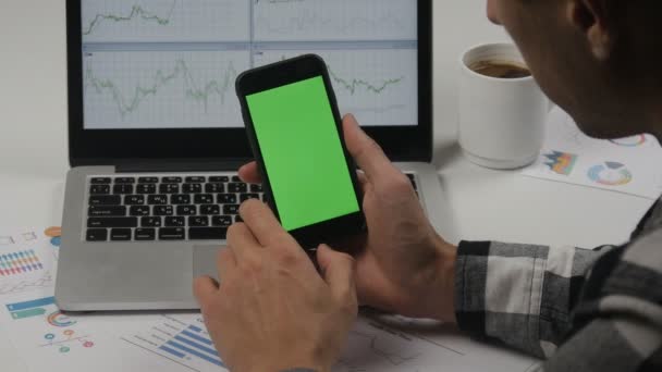 Homme d'affaires utilisant un smartphone avec écran vert sur fond de table de bureau blanc. Vue de dessus. Mains masculines défilant les pages, zoomant, tapant sur l'écran tactile. Bureau fond de bureau — Video