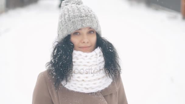 Porträt einer schönen jungen Frau mit Hut an einem verschneiten Wintertag im Freien — Stockvideo