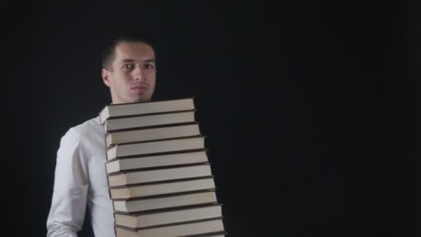 Le jeune homme prend une pile de livres. Homme d'affaires avec des livres dans les mains . — Video