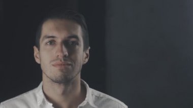 Kameraya bakarak ve gülümseyen Beyaz tişörtlü genç mutlu adam