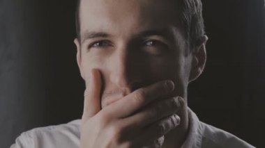 Closeup şüpheci adam ayakta slowmotion hayal kırıklığı ile dört gözle siyah arka plan üzerine. Yüz duygular