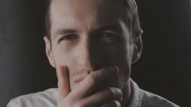 Closeup şüpheci adam ayakta slowmotion hayal kırıklığı ile dört gözle siyah arka plan üzerine. Yüz duygular