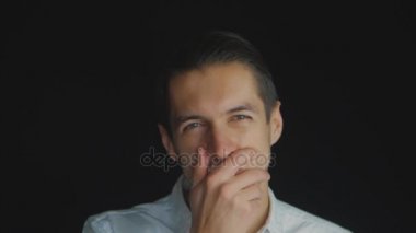 Closeup şüpheci adam ayakta slowmotion hayal kırıklığı ile dört gözle siyah arka plan üzerine. Yüz duygular