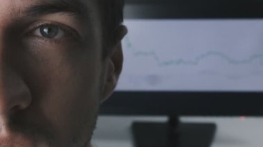 yakın çekim yüz genç işadamı monitörde ticaret zamanlama arka planı.