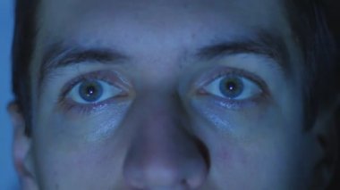 Bir video ya da Tv veya bilgisayar monitörü film izlerken bir genç adamın kapatın. Yansıma yüzünde