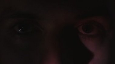 Bir video ya da Tv veya bilgisayar monitörü film izlerken bir genç adamın kapatın. Yansıma yüzünde