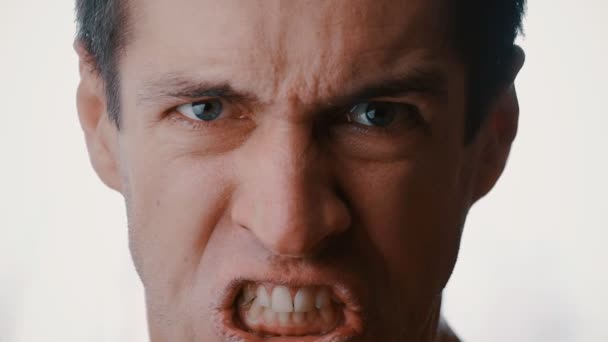 Gros plan sur le visage d'un jeune homme en colère criant de fureur et menaçant de violence — Video