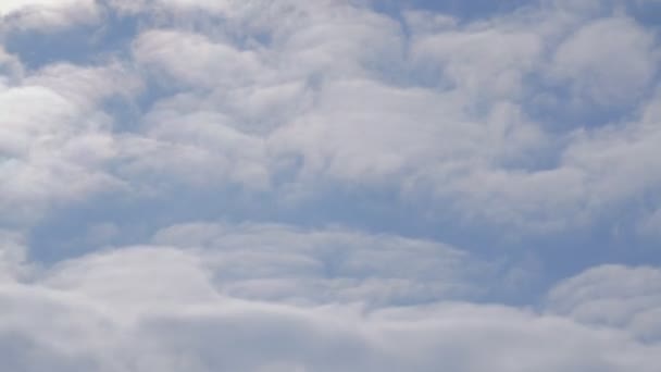 美しい青い空、雲は左に移動します。空飛ぶ飛行機の窓からの眺め。雲の中で飛行 — ストック動画