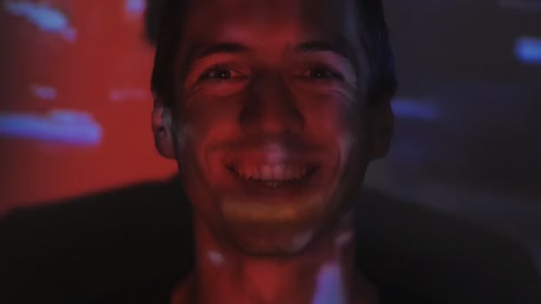 portrait d'un jeune homme regardant une vidéo ou un film à la télévision ou sur un écran d'ordinateur. Réflexion sur son visage 