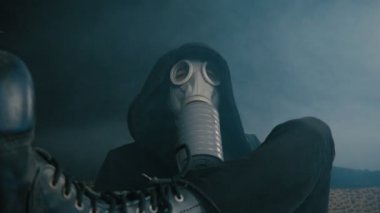 Karanlık bir odada duman oturarak bir gaz maskeli adam. Kıyamet sonrası dünyada STALKER