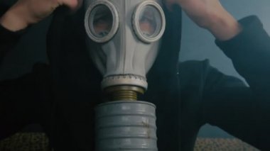 Karanlık bir odada duman oturarak bir gaz maskeli adam. Kıyamet sonrası dünyada STALKER