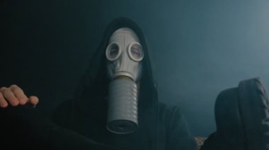 Karanlık bir odada duman oturarak bir gaz maskeli adam. Kıyamet sonrası dünyada STALKER