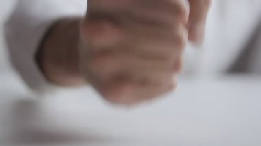 Öfke kavramı. Adam beyaz arka plan saldırganlık gösteren tablo üzerinde yumruk atıyor