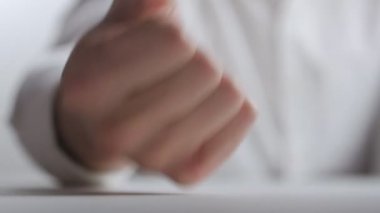 yakın çekim agresif katip masaya yumruk atıyor. Saldırganlık ofiste iş yerinde tezahürü.