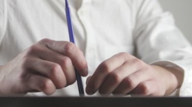 Elinde bir şey bekliyor yorgun işadamı kapatın ve kalem ile sinirli hareketler yapar
