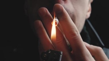 Acımasız bir adamın gece yavaş çekimde bir sigara yakın çekim.