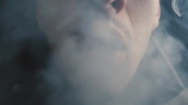 Acımasız bir adamın gece yavaş çekimde bir sigara yakın çekim.