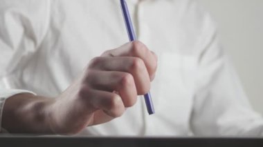 Elinde bir şey bekliyor yorgun işadamı kapatın ve kalem ile sinirli hareketler yapar