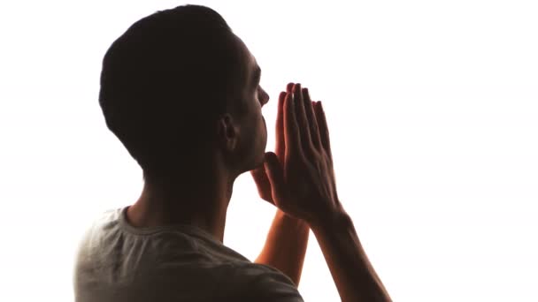 Σιλουέτα ενός ανθρώπου που προσεύχεται στο Θεό. Έννοια της πίστης και της θρησκείας — Αρχείο Βίντεο