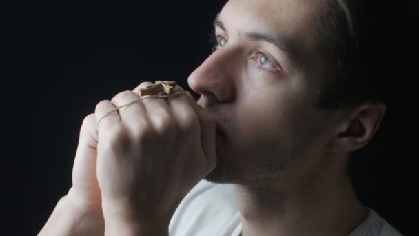 Close up van een jonge man bidden tot God. Concept van geloof en religie — Stockvideo