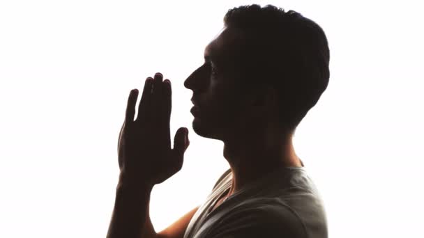 Silueta de la mano de un hombre rezando, de cerca — Vídeos de Stock