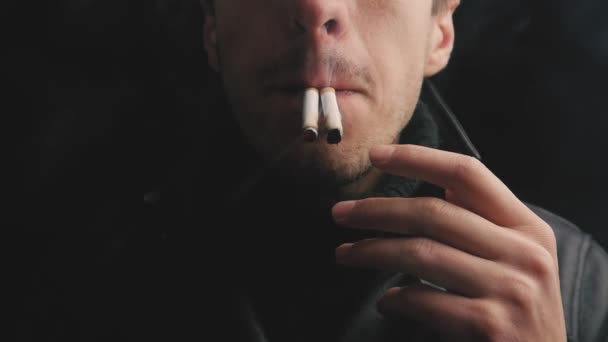 Gros plan du jeune homme fume deux cigarettes à la fois . — Video