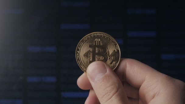 Ο άνθρωπος τα χέρια κρατούν χρυσό Bitcoin σε δυαδικό κώδικα φόντο. εξόρυξη και εμπορία — Αρχείο Βίντεο