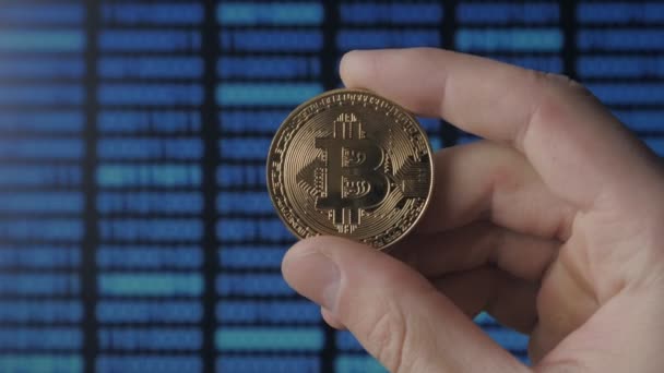 Uomo mani tenere Bitcoin oro su sfondo codice binario. estrazione e commercio — Video Stock