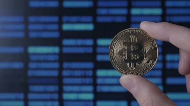 Hombre manos sostienen de oro Bitcoin en el fondo de código binario. minería y comercio — Vídeos de Stock